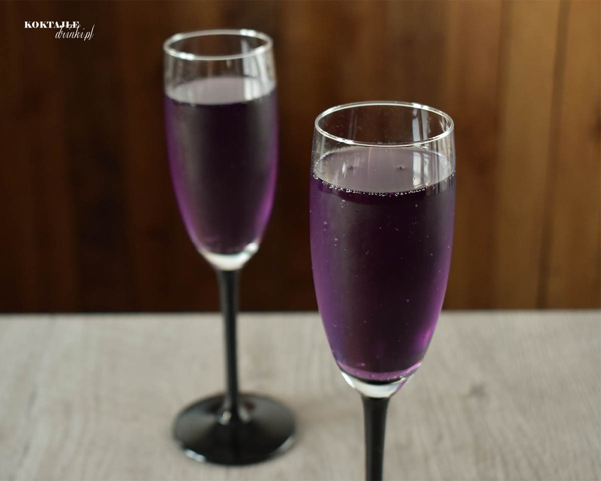 Drugie ujęcie na purpurowe drinki z szampanem Prosecco w kieliszkach od szampana w dalszym oddaleniu