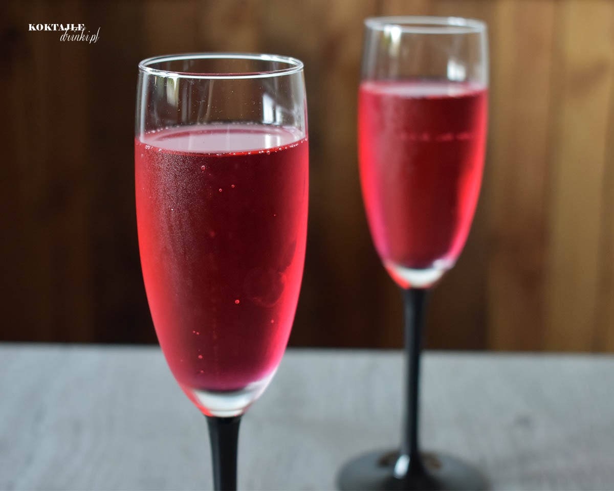 Widok na dwa kieliszki z szampanem Prosecco w barwie czerwonej dzięki grenadynie.
