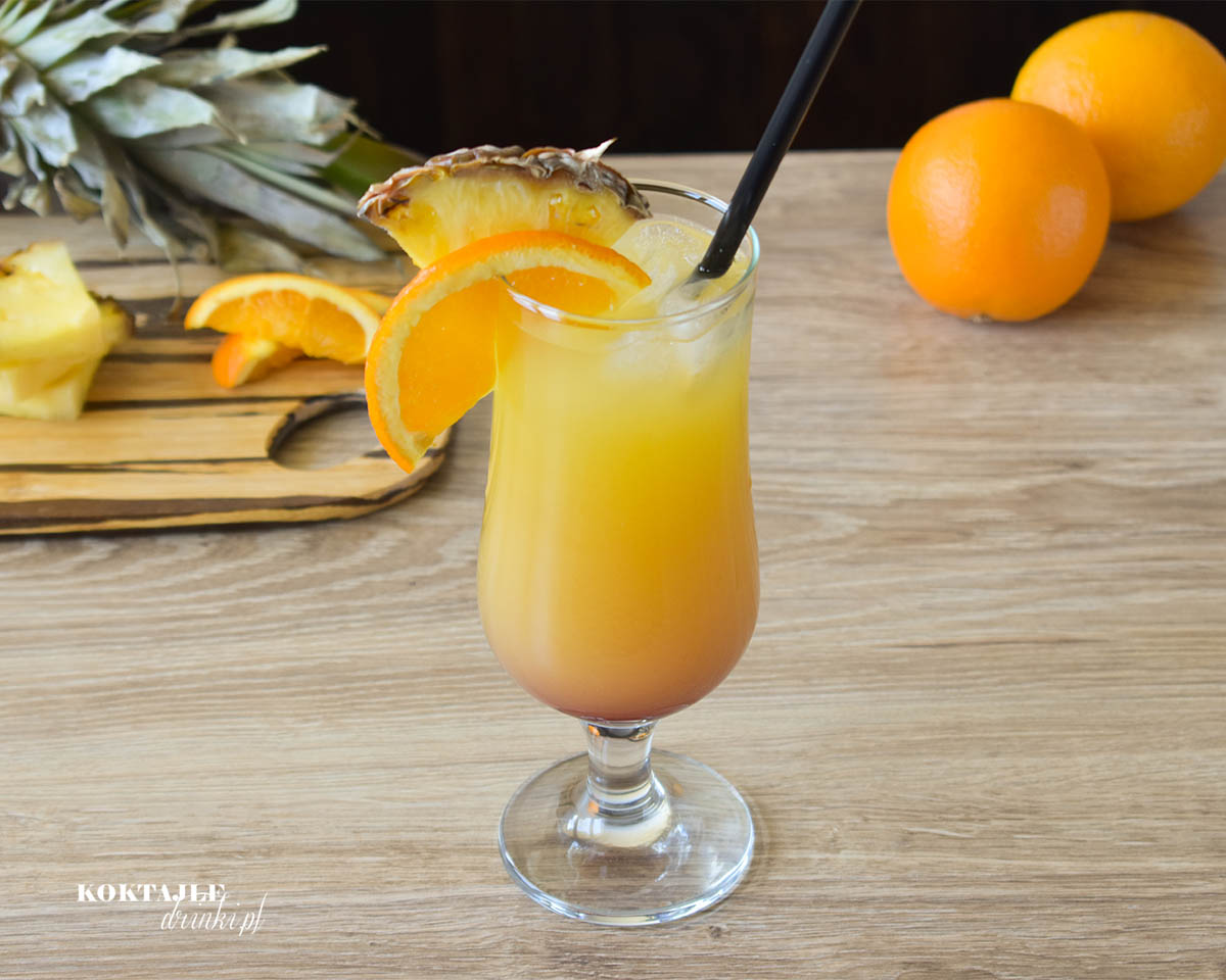 Drink Exotic Summernight w ujęciu drugim z połączenia dwóch soków ananasowego i pomarańczowego. Z efektem wschodu słońca z grenadyną na dnie.