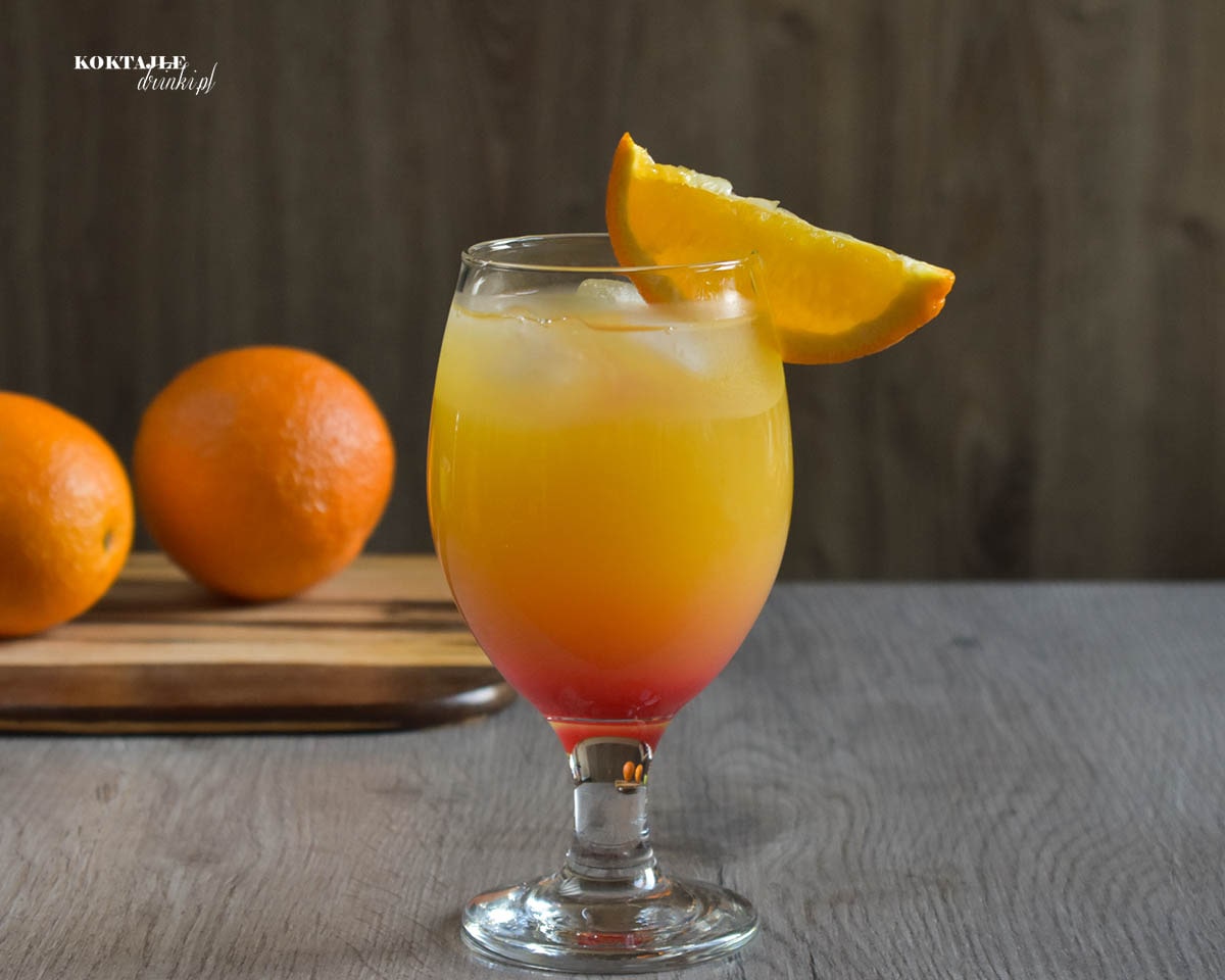 Widok od frontu na dwu warstwowy drink Gin Summer Night, czerwień na dole powoli ku górze łącząca się z pomarańczą.