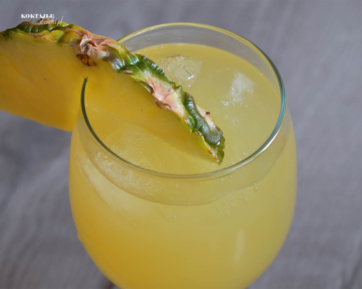 Drink San Juan Cooler w ujęciu drugim z góry, w przybliżeniu na kawałek ananasa użytego do ozdoby.